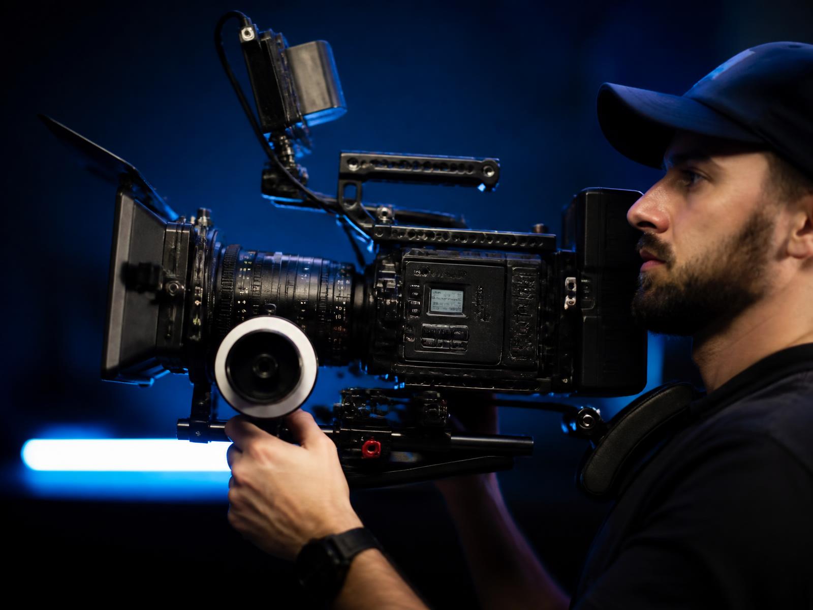 Operator with a fully rigged shoulder-mount cinema camera and matte box