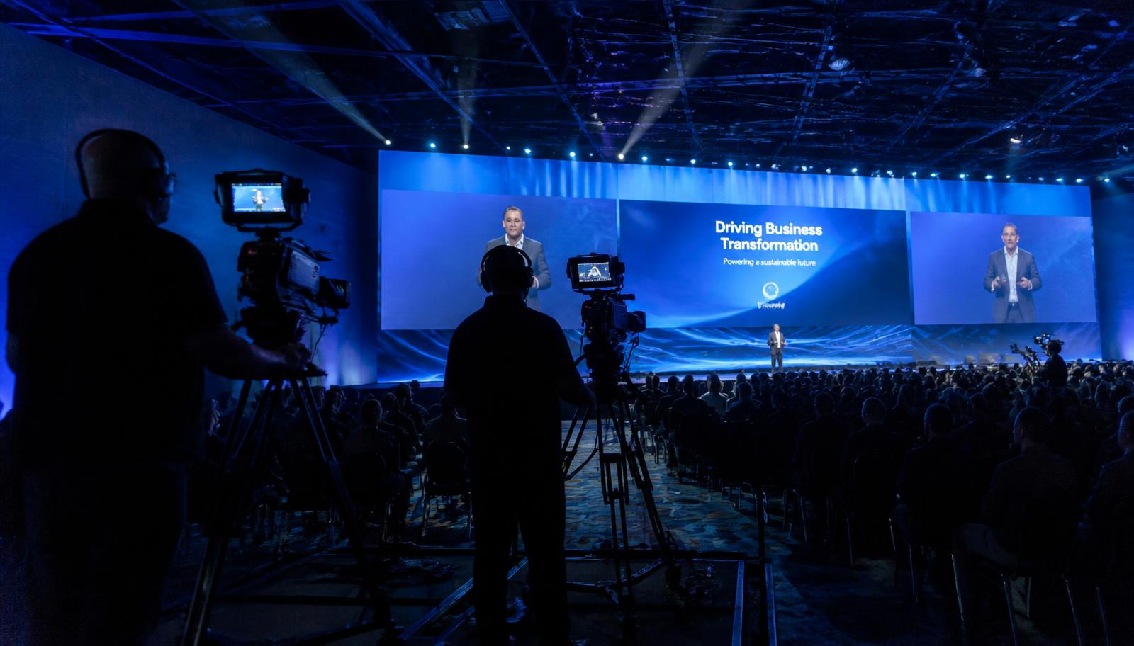 Multi-camera crew filming a corporate conference stage