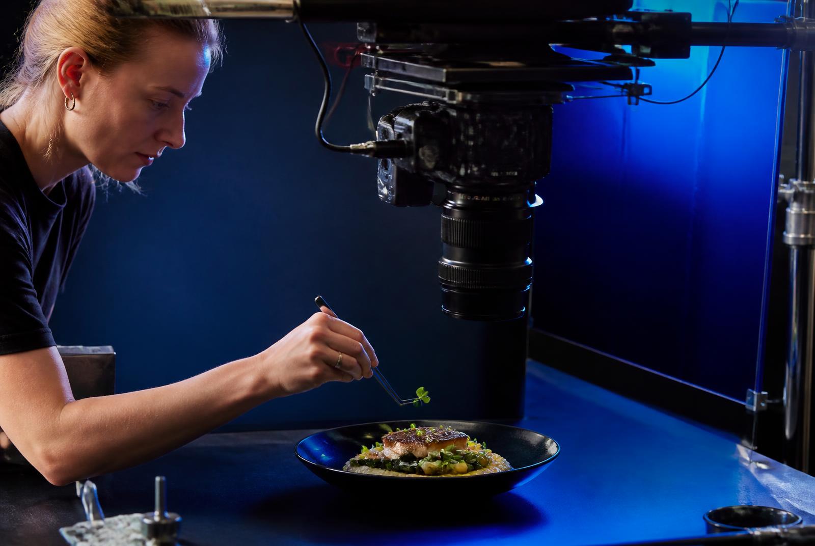 Food stylist plating a dish under an overhead camera rig — FMCG video production in Mumbai