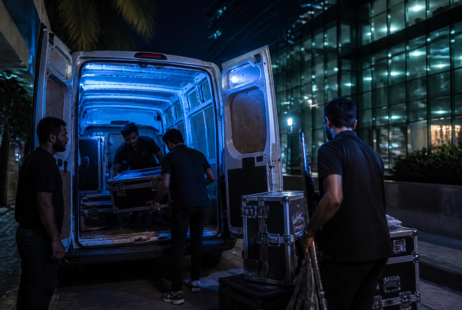 Crew loading flight cases into a production van outside a Mumbai office tower — video production guides for Mumbai brands