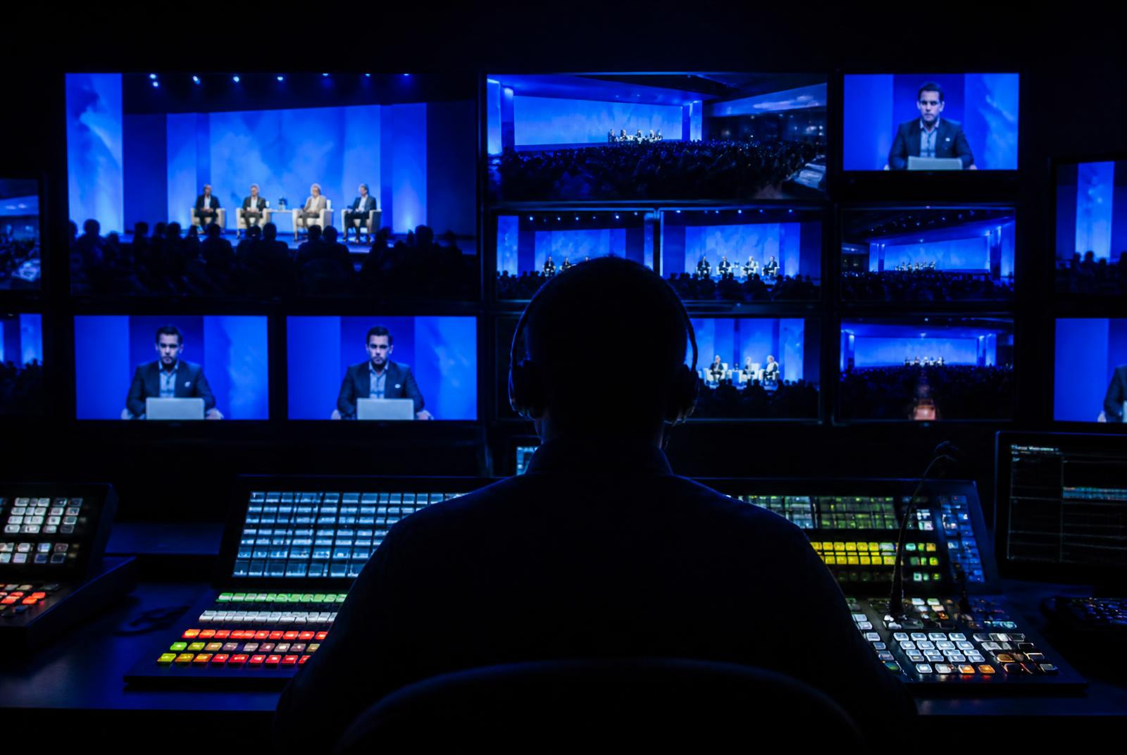 Live production gallery with a vision mixer and wall of camera preview monitors — Event Video Production in Mumbai